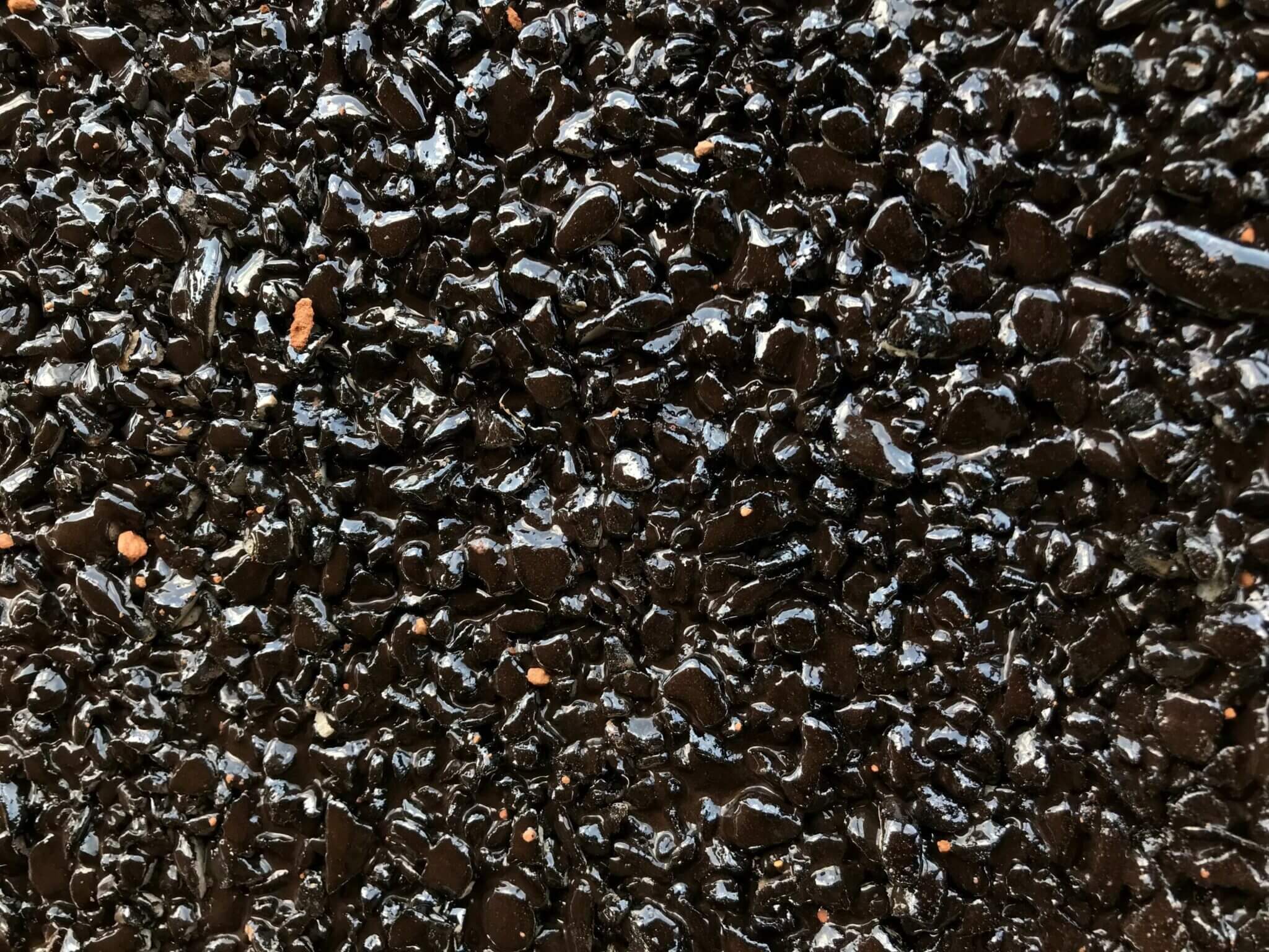 Close-up of a fresh chip seal surface bound with bitumen emulsion